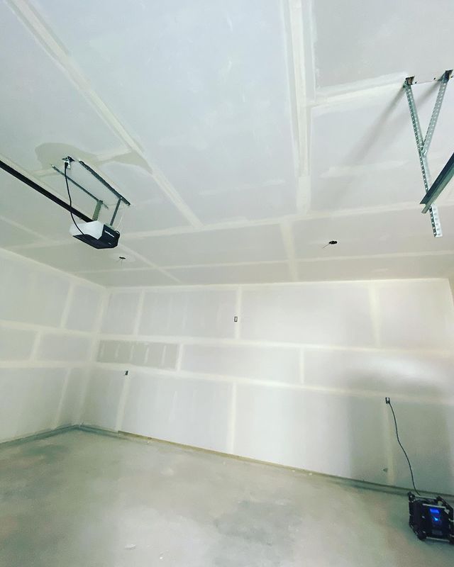 An empty garage with a garage door opener on the ceiling
