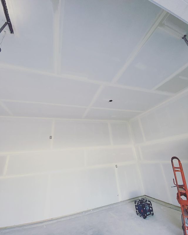A garage with white walls and a ladder in the corner