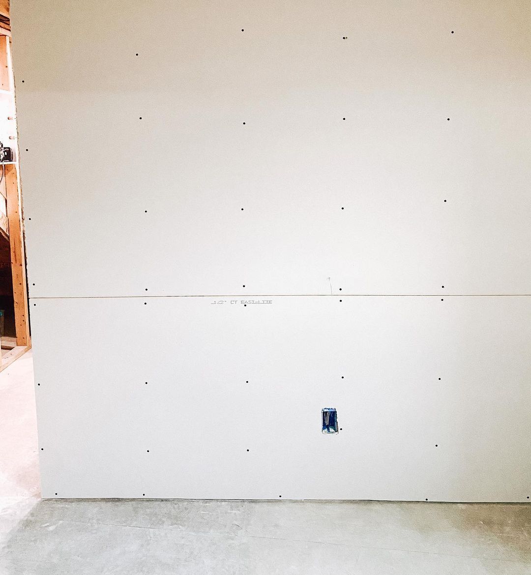 A white wall with a hole in the middle of it