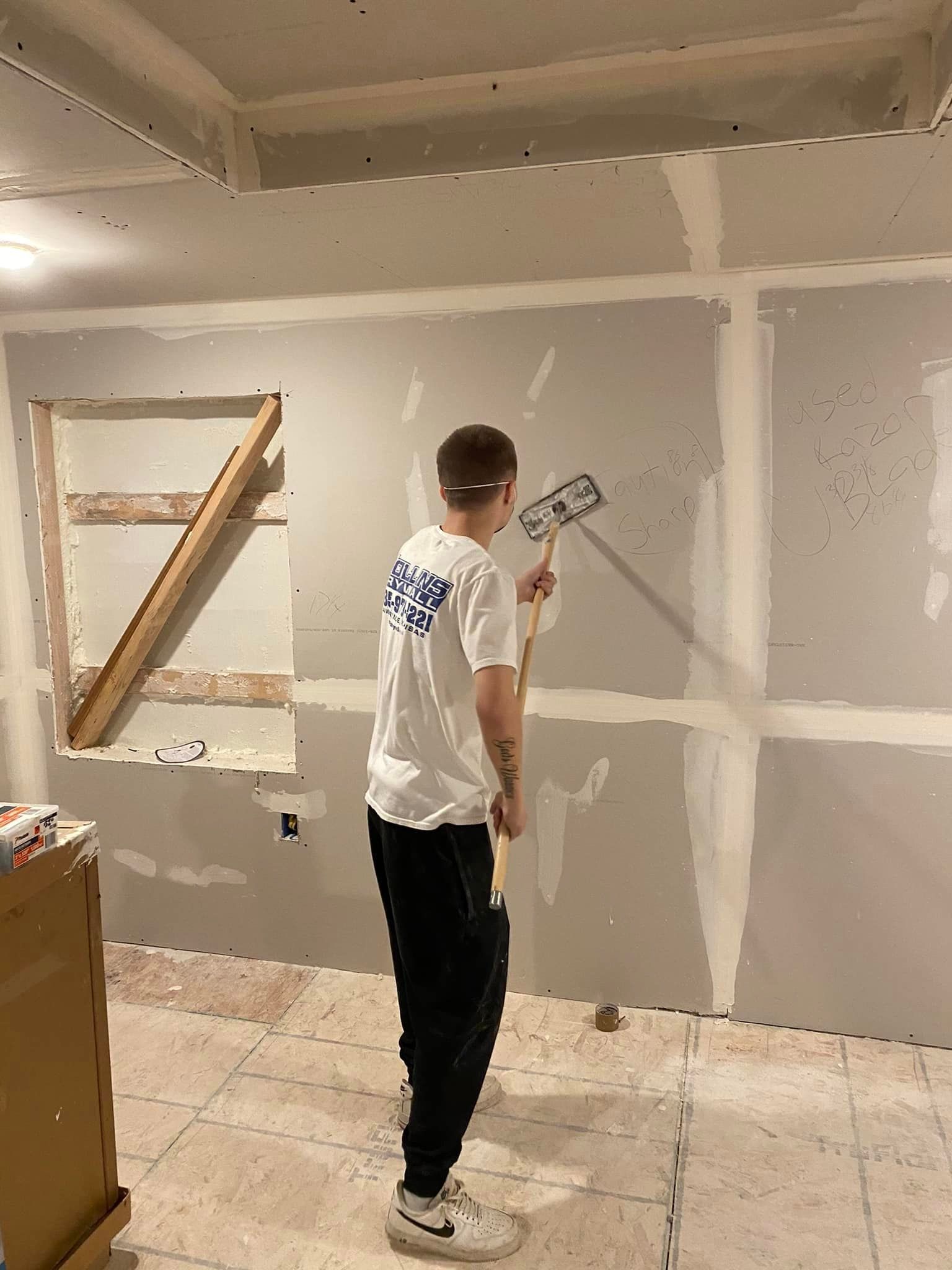 A man is painting a wall with a roller.