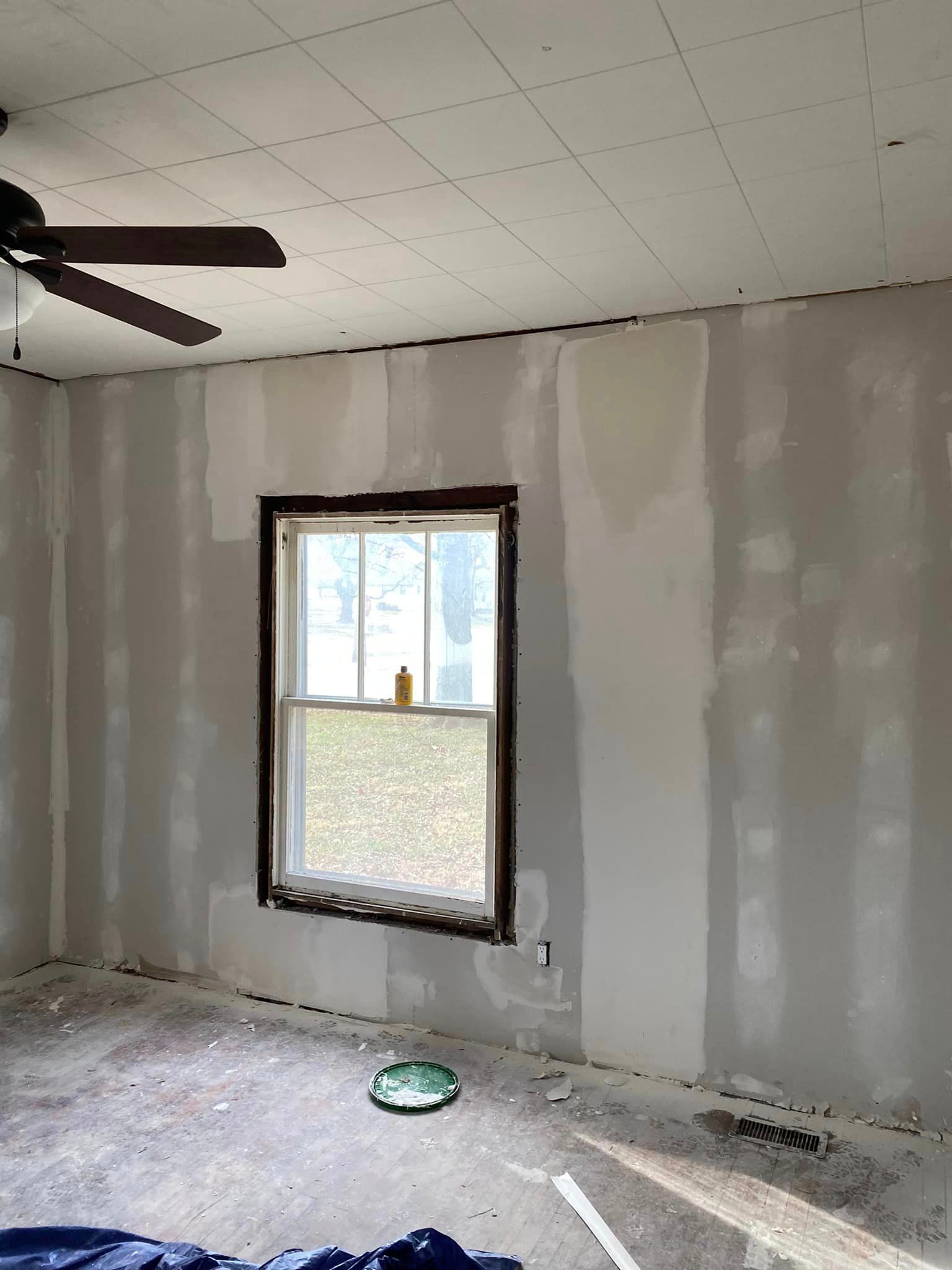 A room with a ceiling fan and a window.