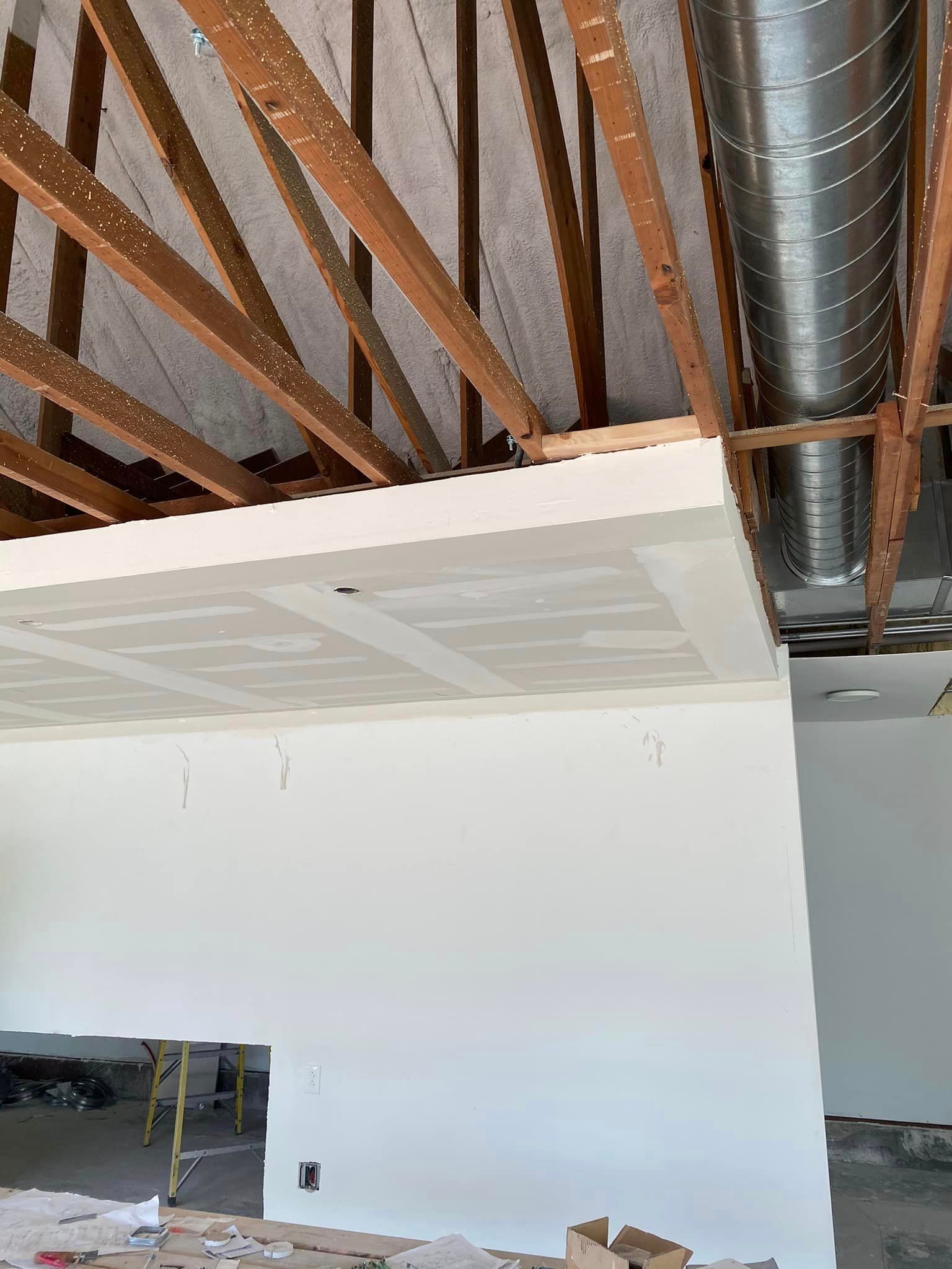 A room with a ceiling that is being built with wooden beams.