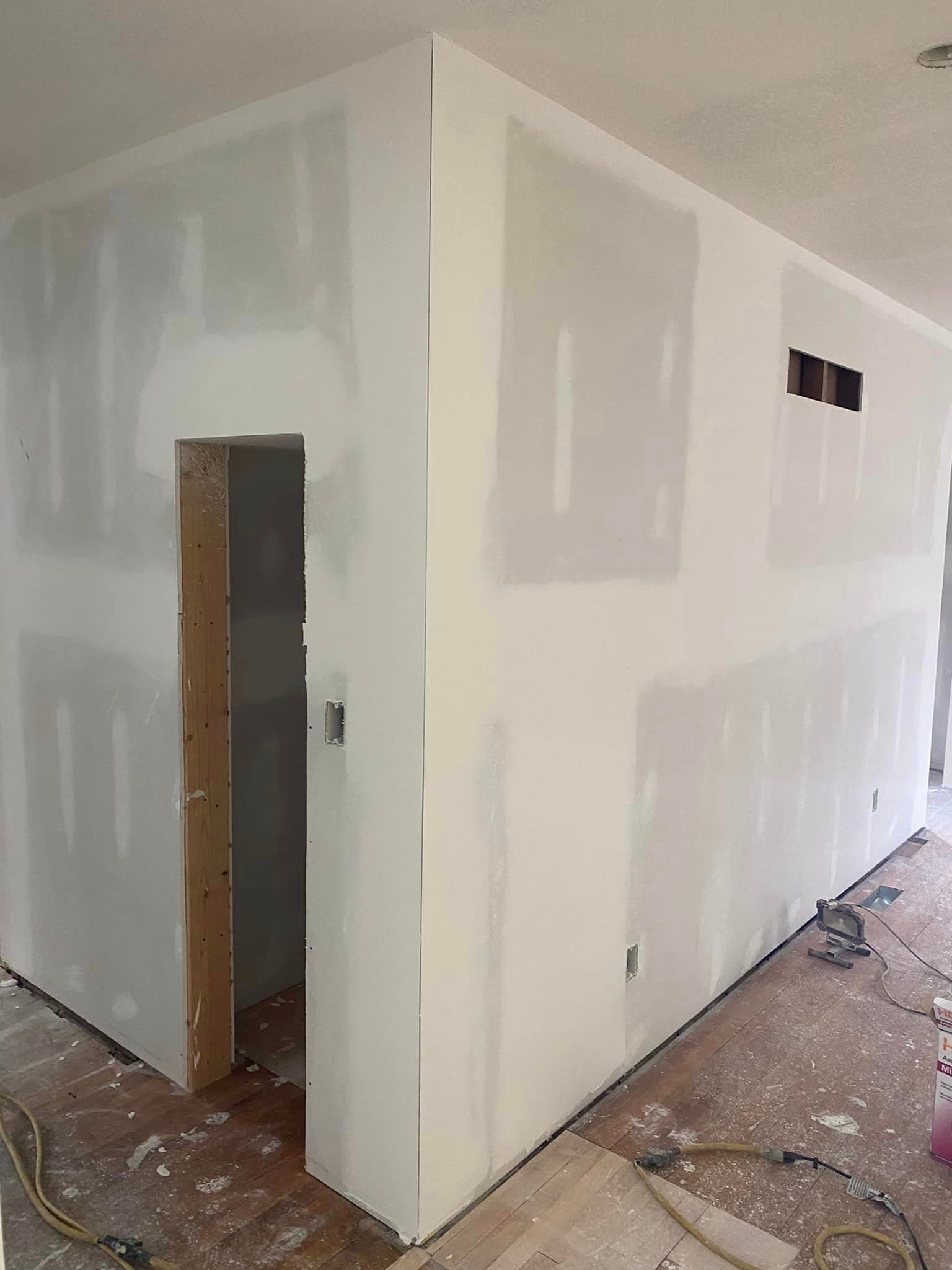 A room with drywall walls and a door.