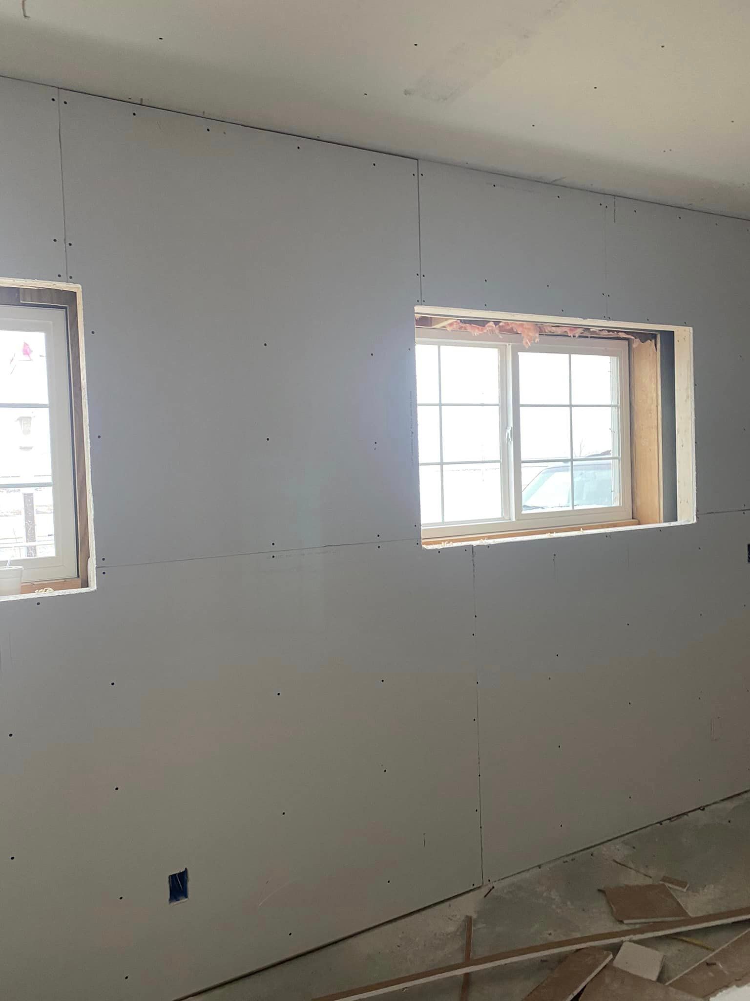 A room with two windows and a white wall