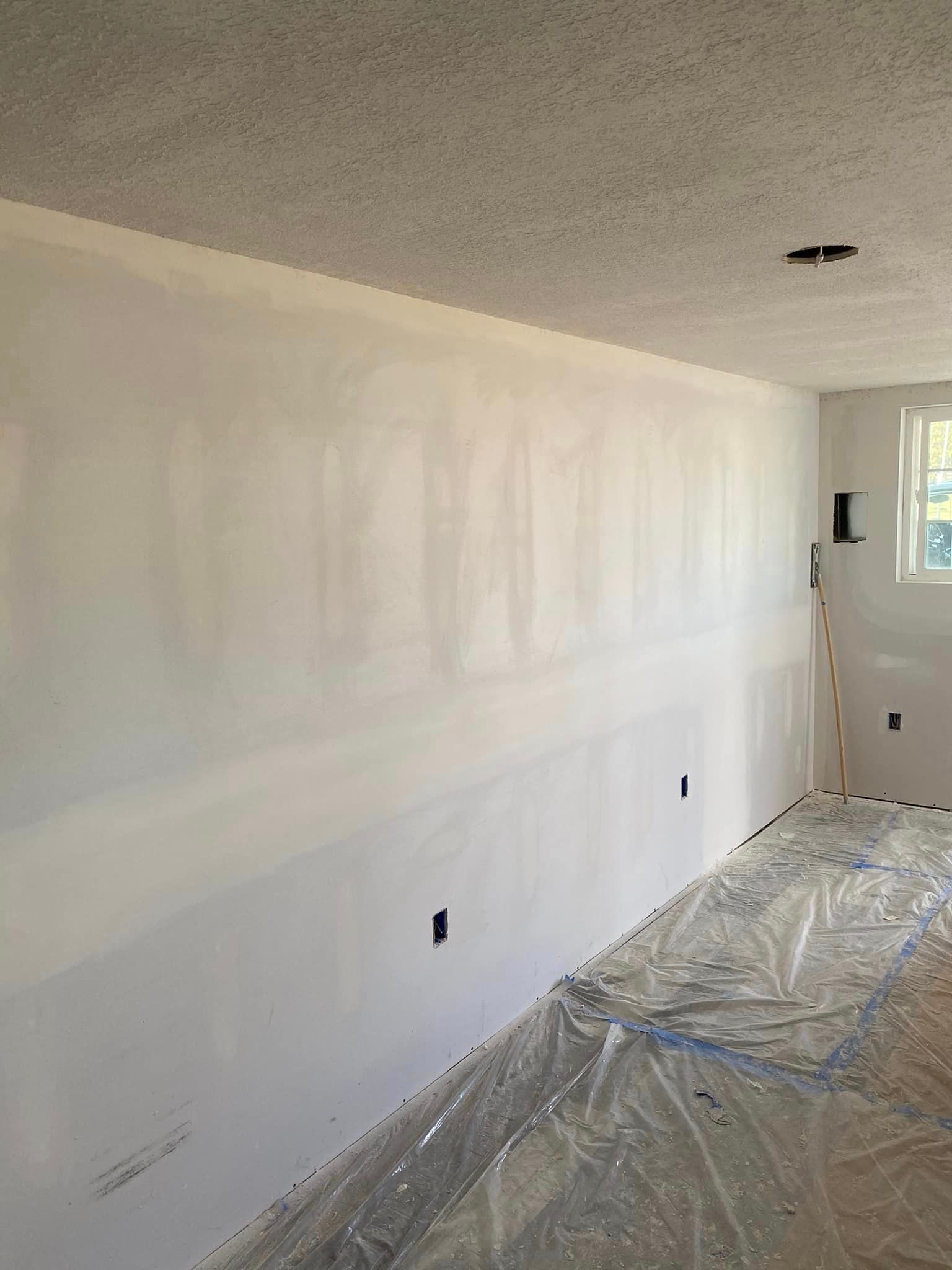 A room with a lot of white walls and a window.