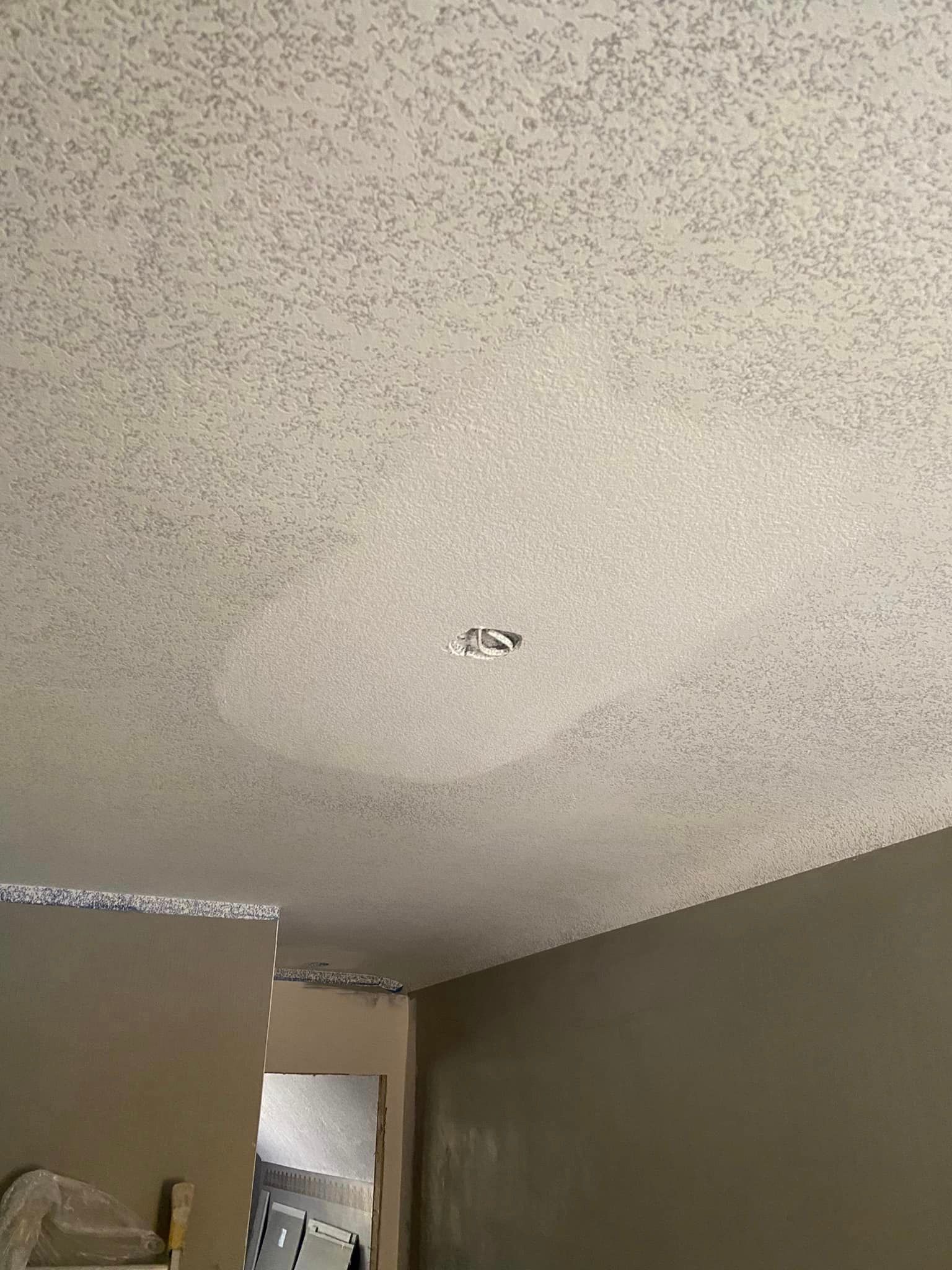 A ceiling with a hole in it in a room.