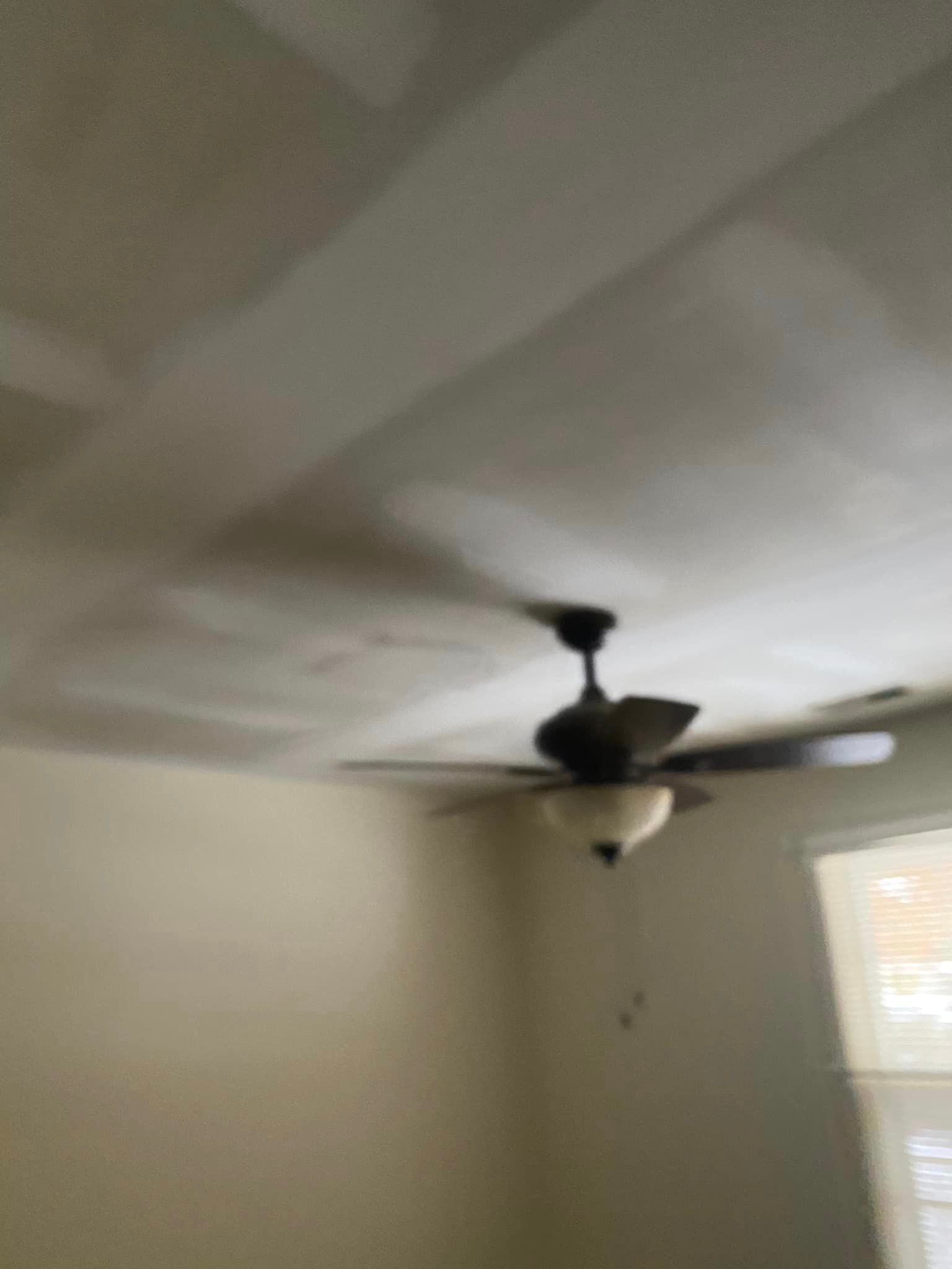 A ceiling fan is hanging from the ceiling of a room.