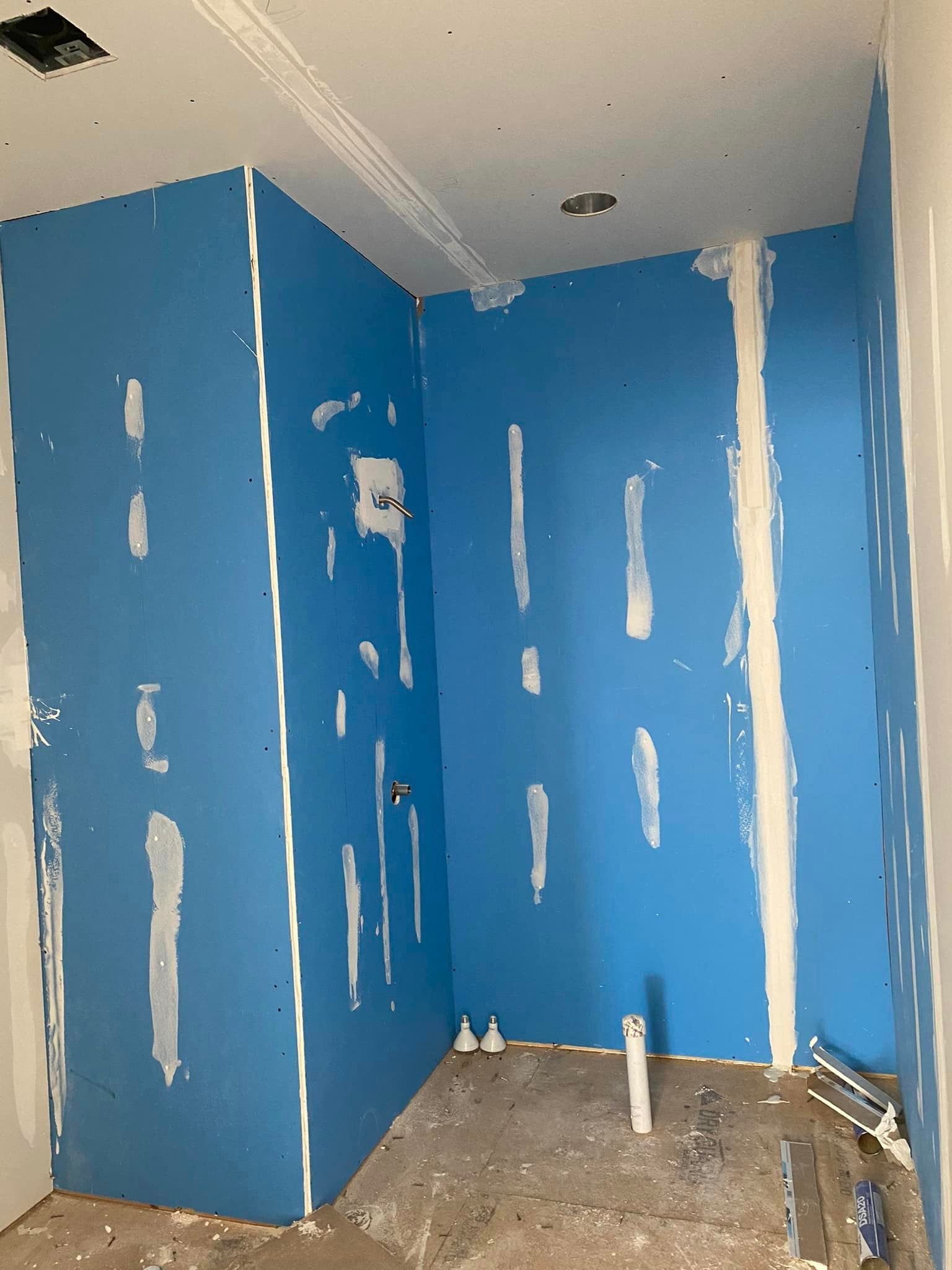 A room with blue walls and white trim is being remodeled.