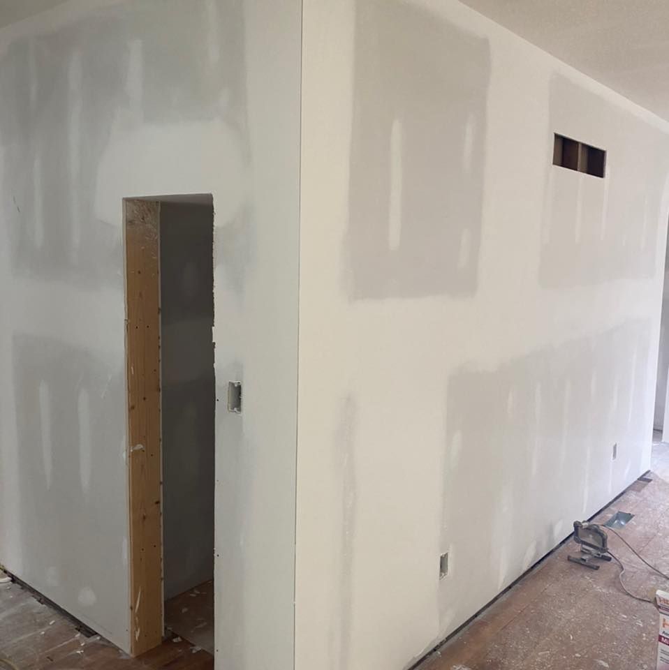 A room with drywall walls and a door.