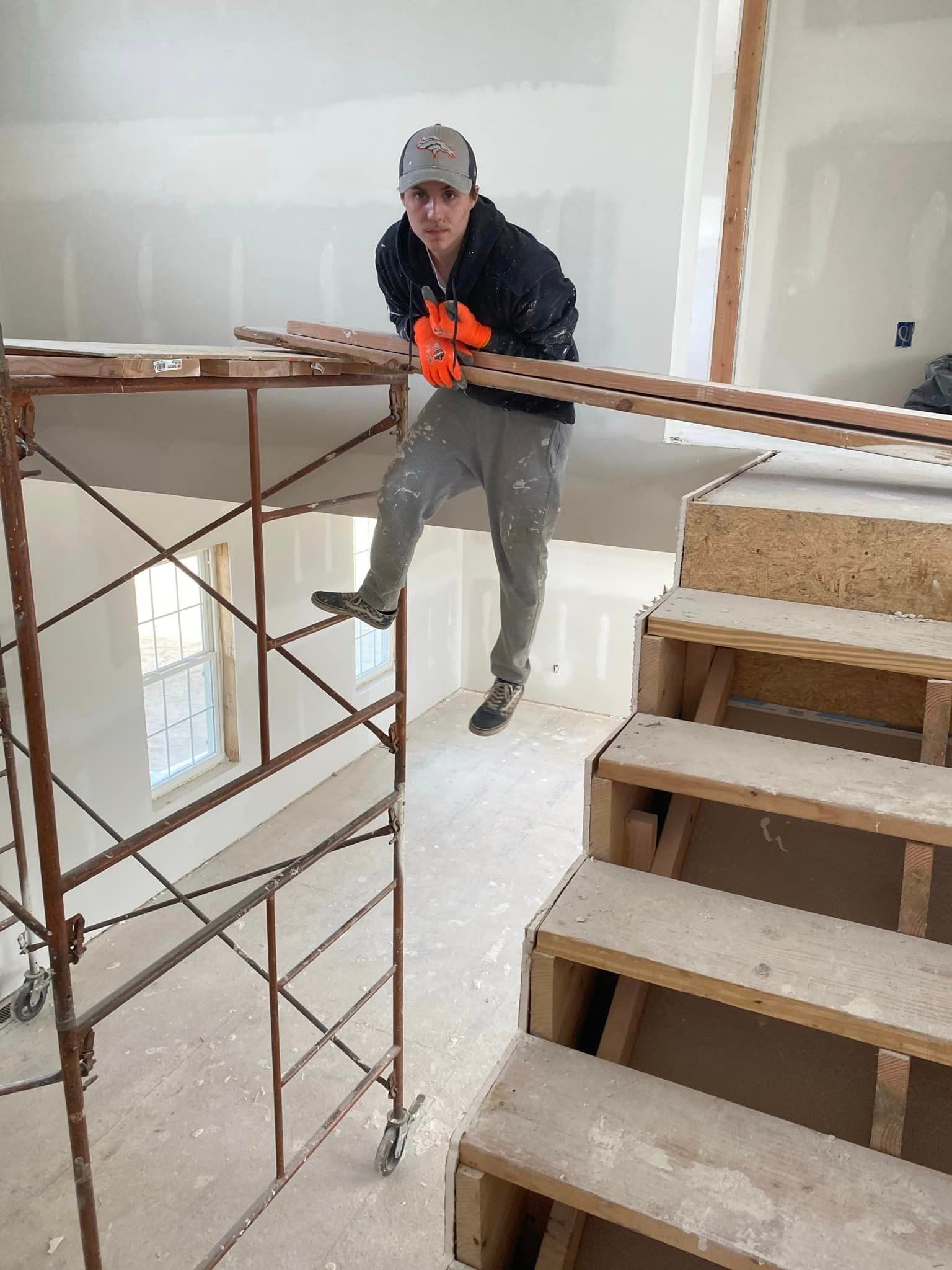 A man is standing on a scaffolding next to a set of stairs.