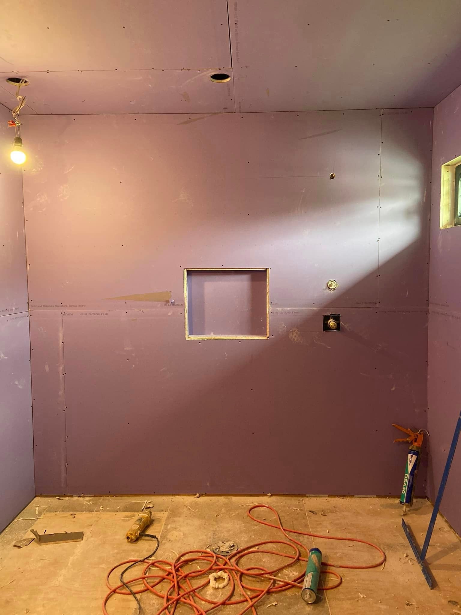 A room with purple walls and a hole in the wall.