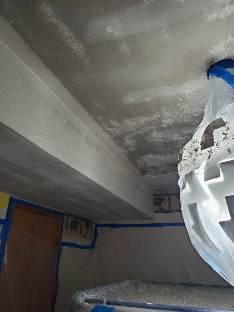 A room with a ceiling that is being painted.