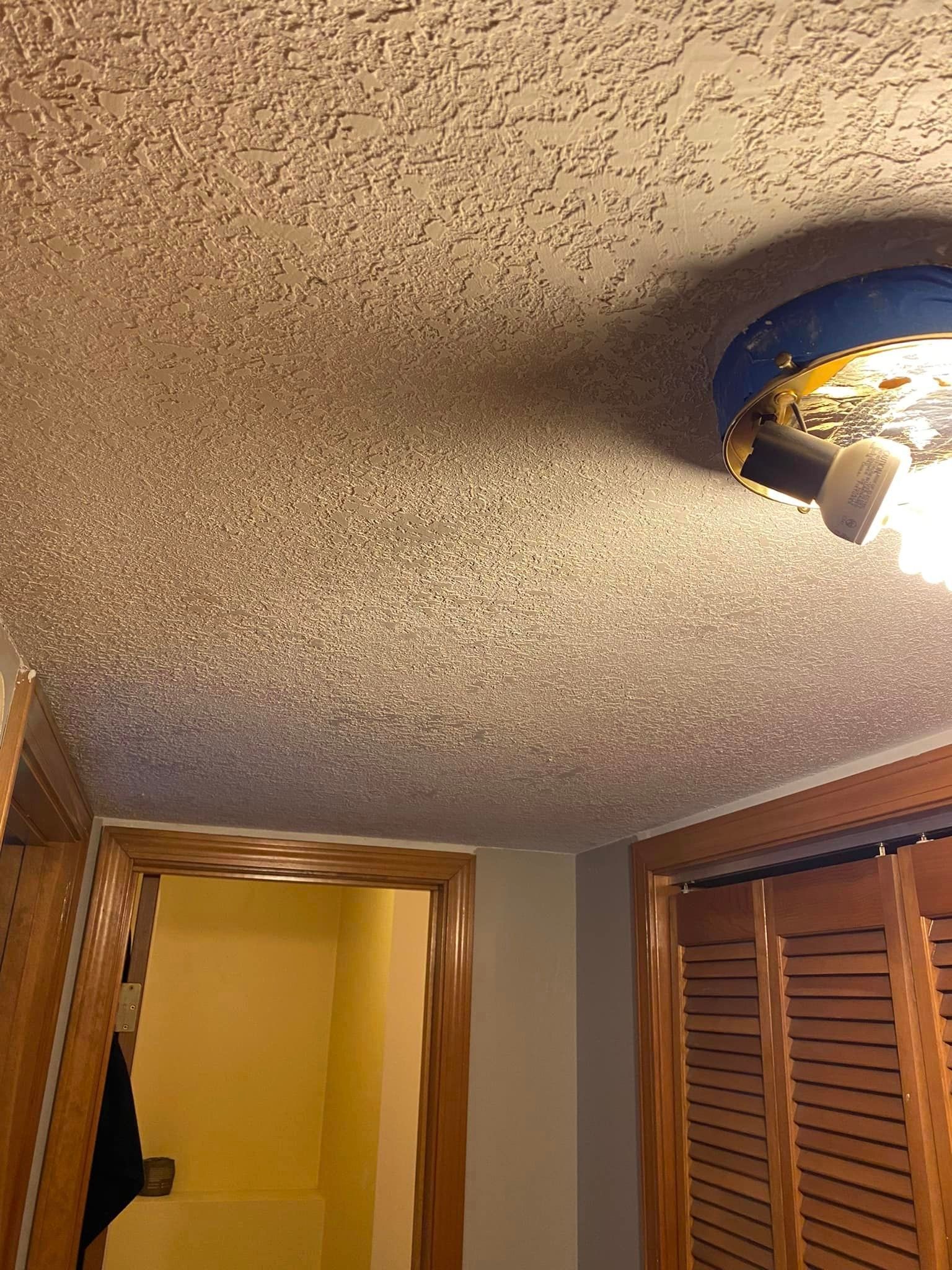 A room with a ceiling light and a door.