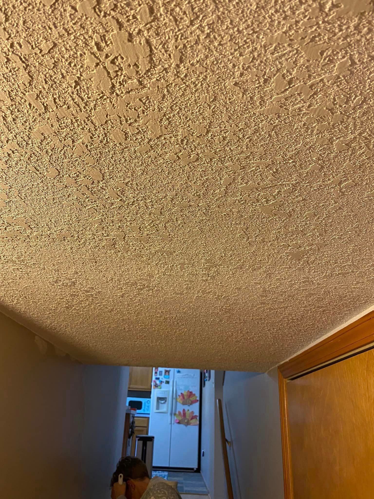 A person is standing in a hallway looking up at the ceiling.