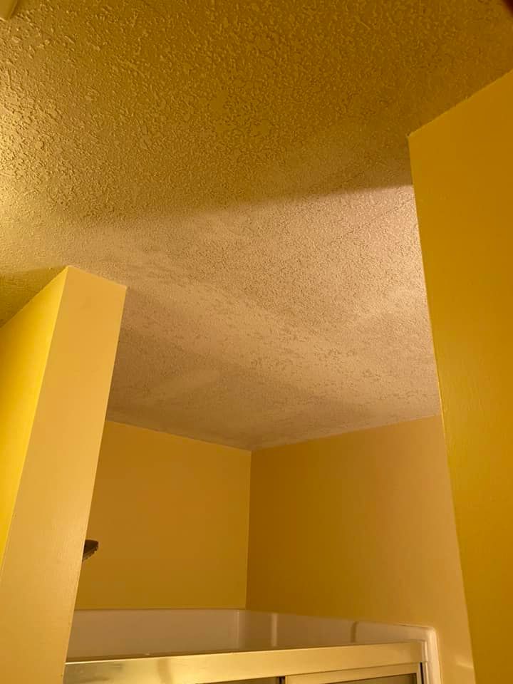 A bathroom with yellow walls and a white ceiling.