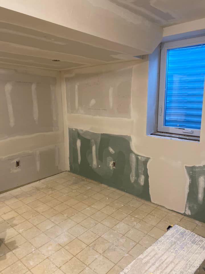 A room with a window and tile floor is being remodeled.