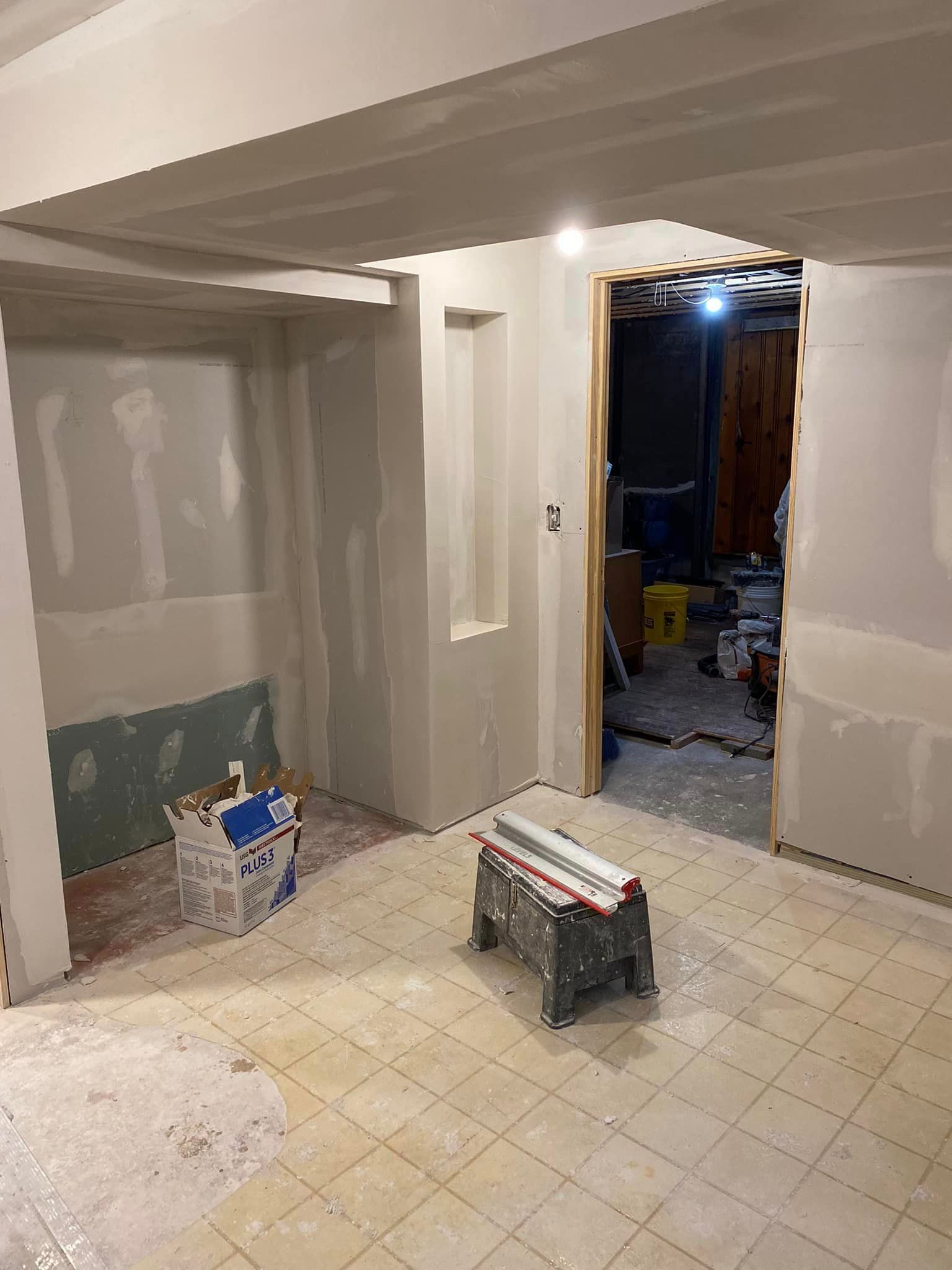 A room with a stool and a box on the floor.