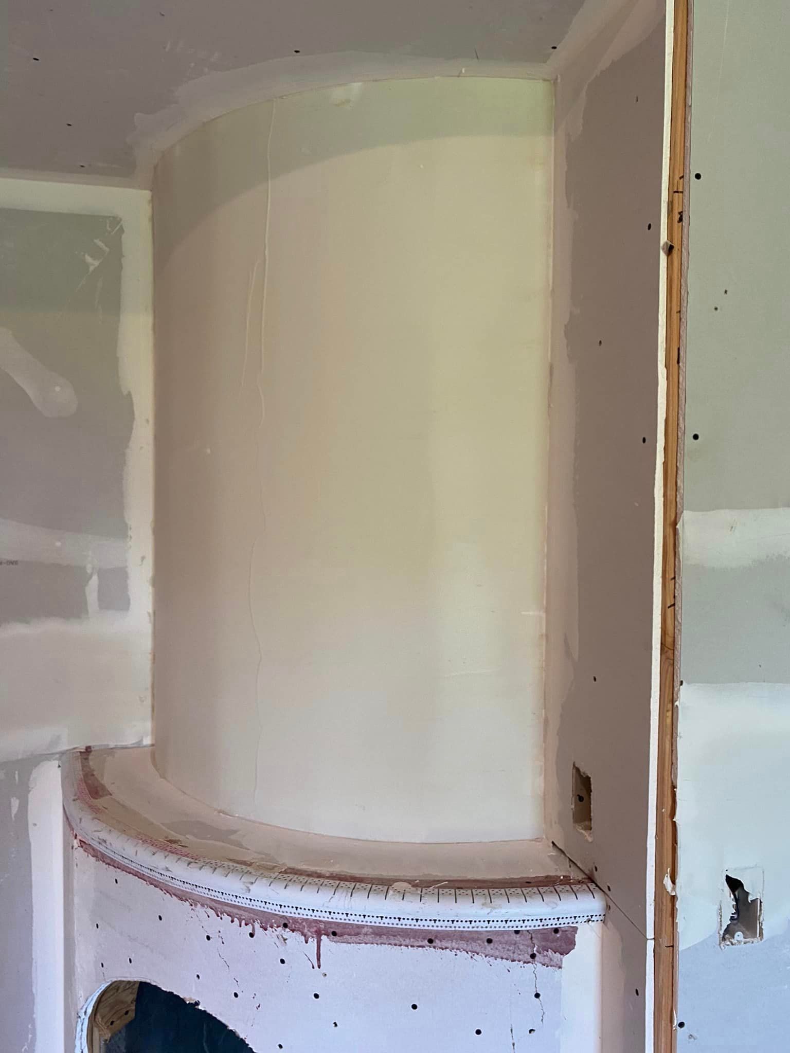 A large white cylinder is sitting in the middle of a room.