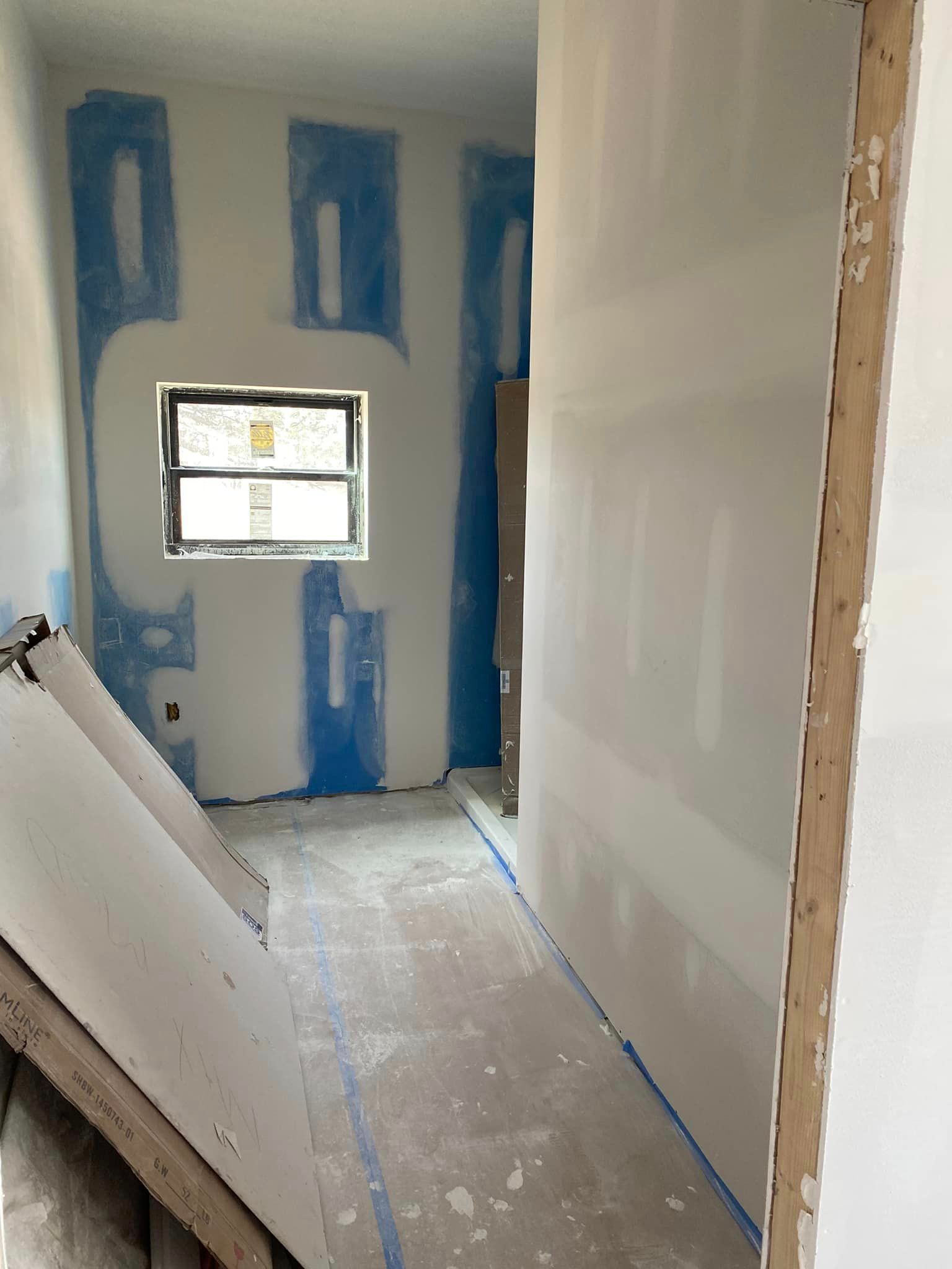 A room that is being remodeled with a window on the wall.