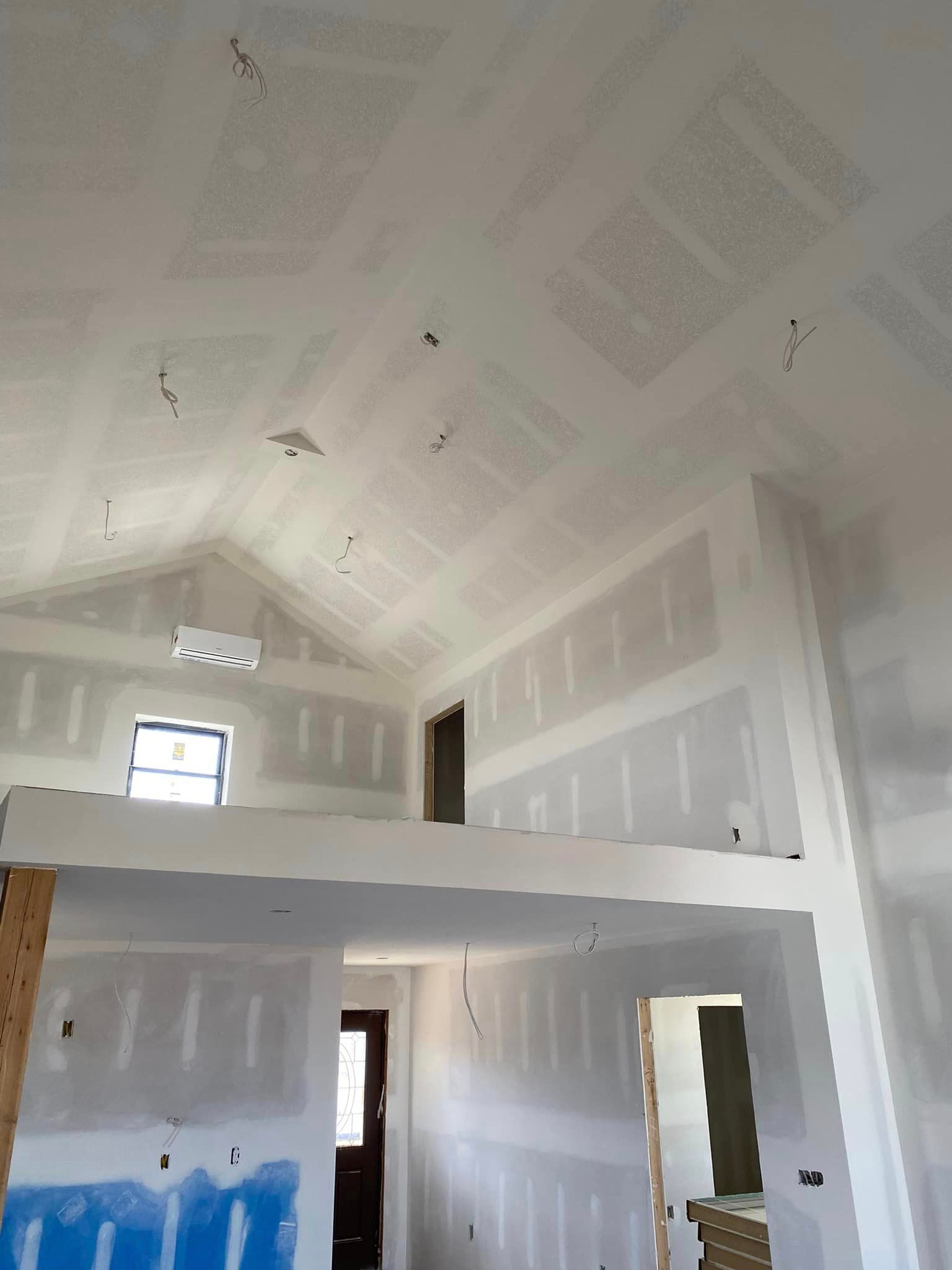 A room with a vaulted ceiling and a balcony.