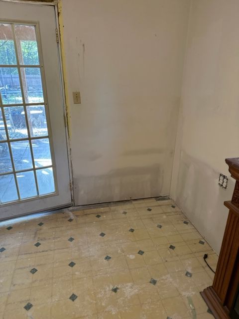 An empty room with a fireplace and a door