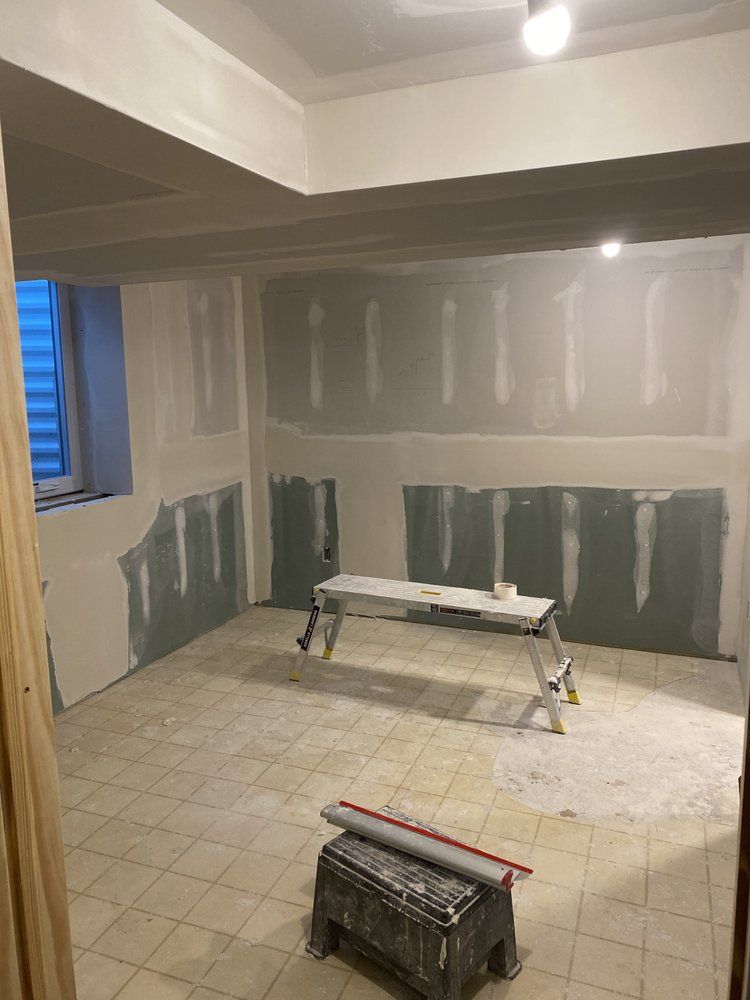 A room with a bench and a ladder in it is being remodeled.