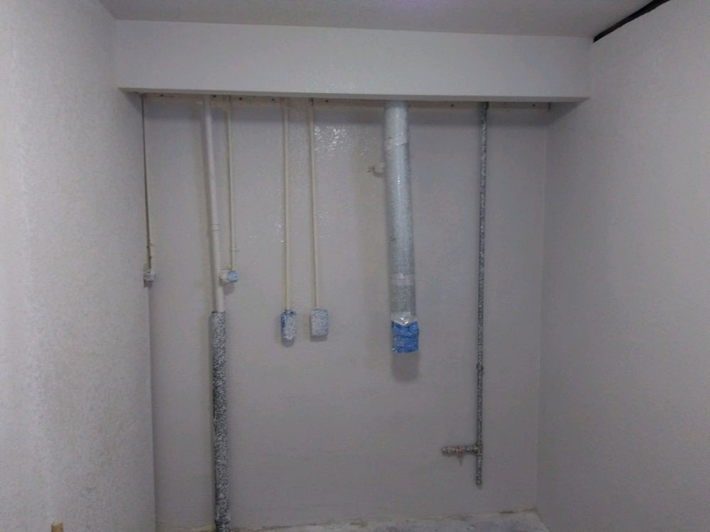 A room with a lot of pipes hanging from the ceiling.