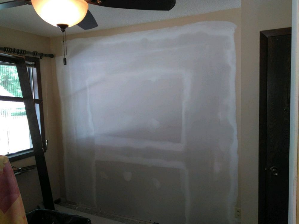 A living room with a fireplace and a ceiling fan