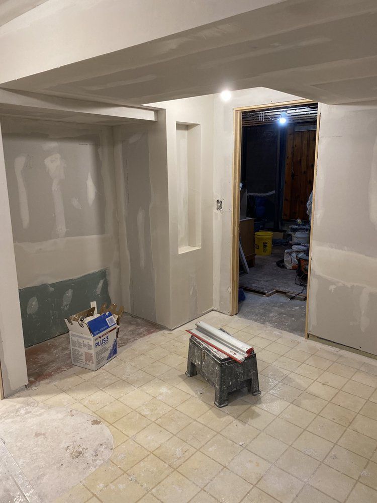 A room with a stool and a box on the floor.