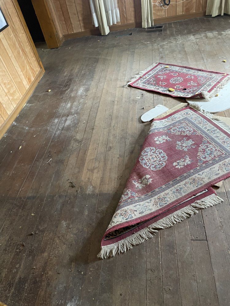 Two rugs are laying on a wooden floor in a room.
