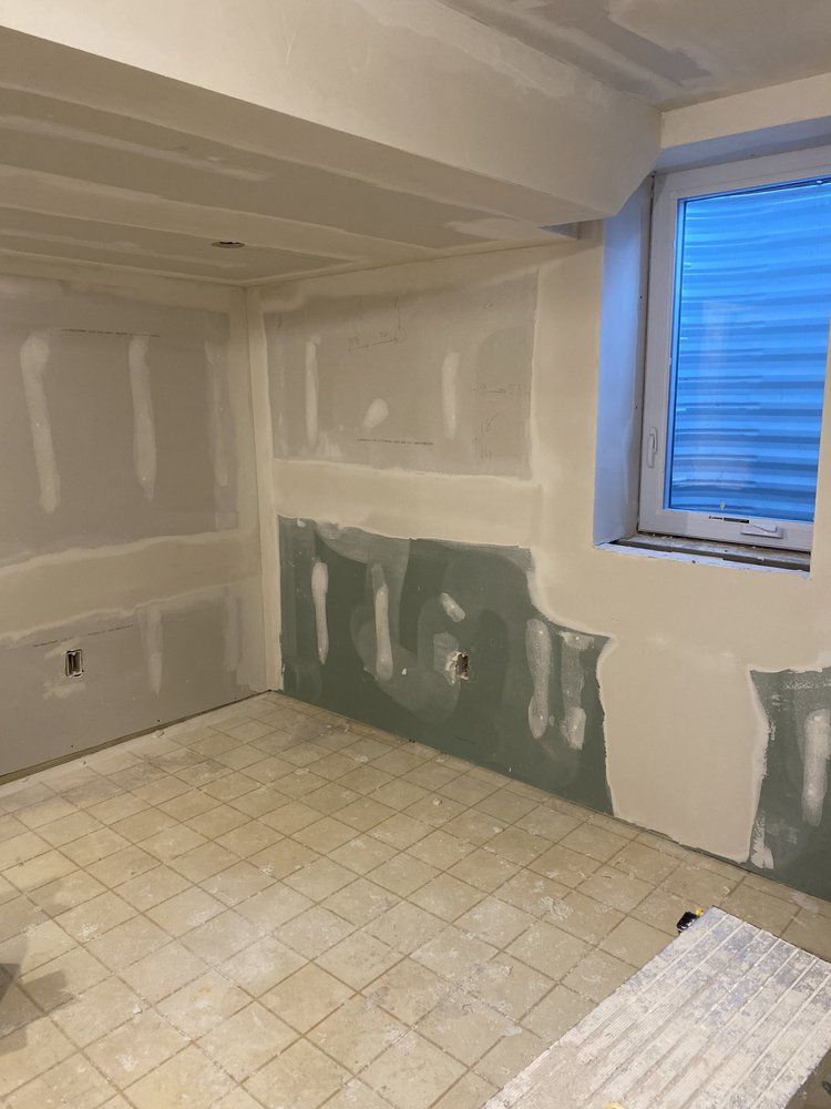 A room with a window and a tiled floor is being remodeled.