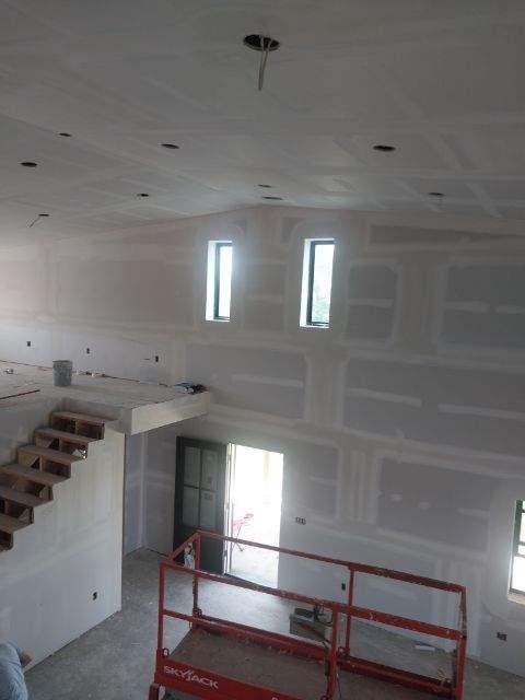 A large room with stairs and a lift in the middle of it.