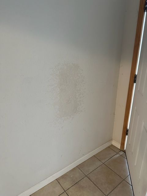 A corner of a room with a door and a white wall.