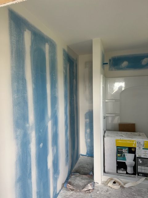 A room with blue walls and a box of toilet paper on the floor