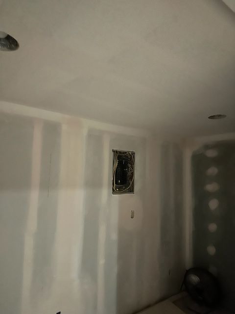 A room with white walls and a ceiling that is being remodeled.