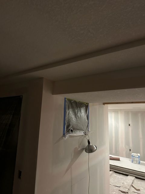 A bag of sand is hanging on a wall in a room.