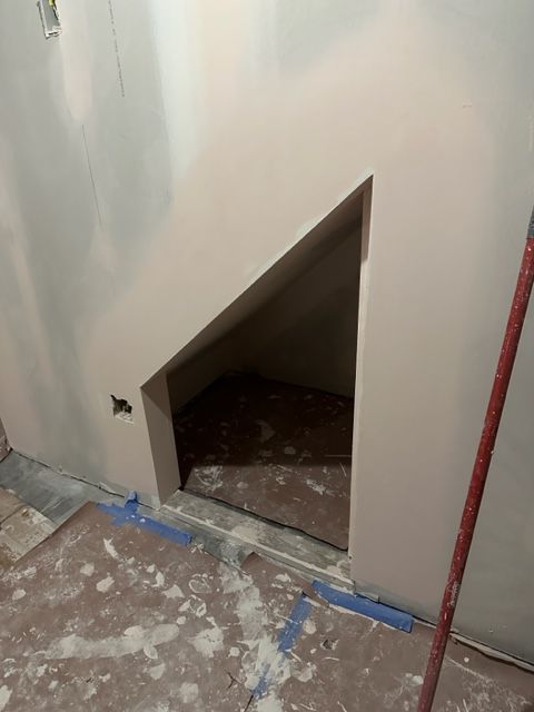 There is a hole in the wall under the stairs.