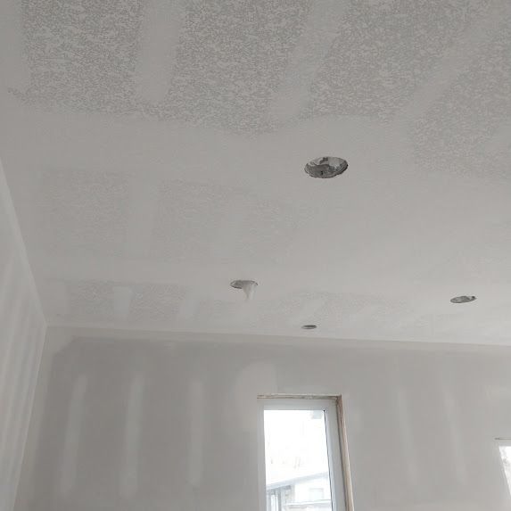 A room with a white ceiling and a window.