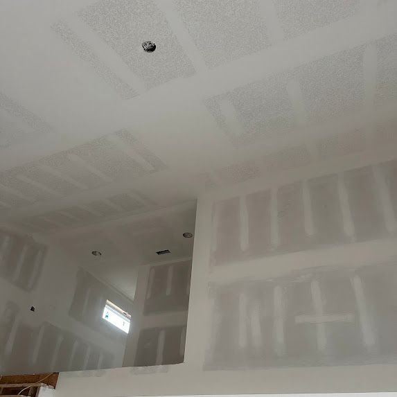 A room with a staircase and drywall on the walls.