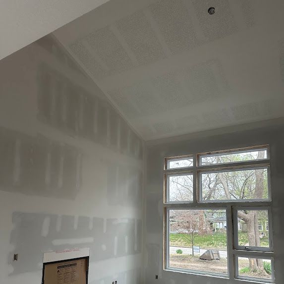 A room with a lot of windows and drywall on the walls.