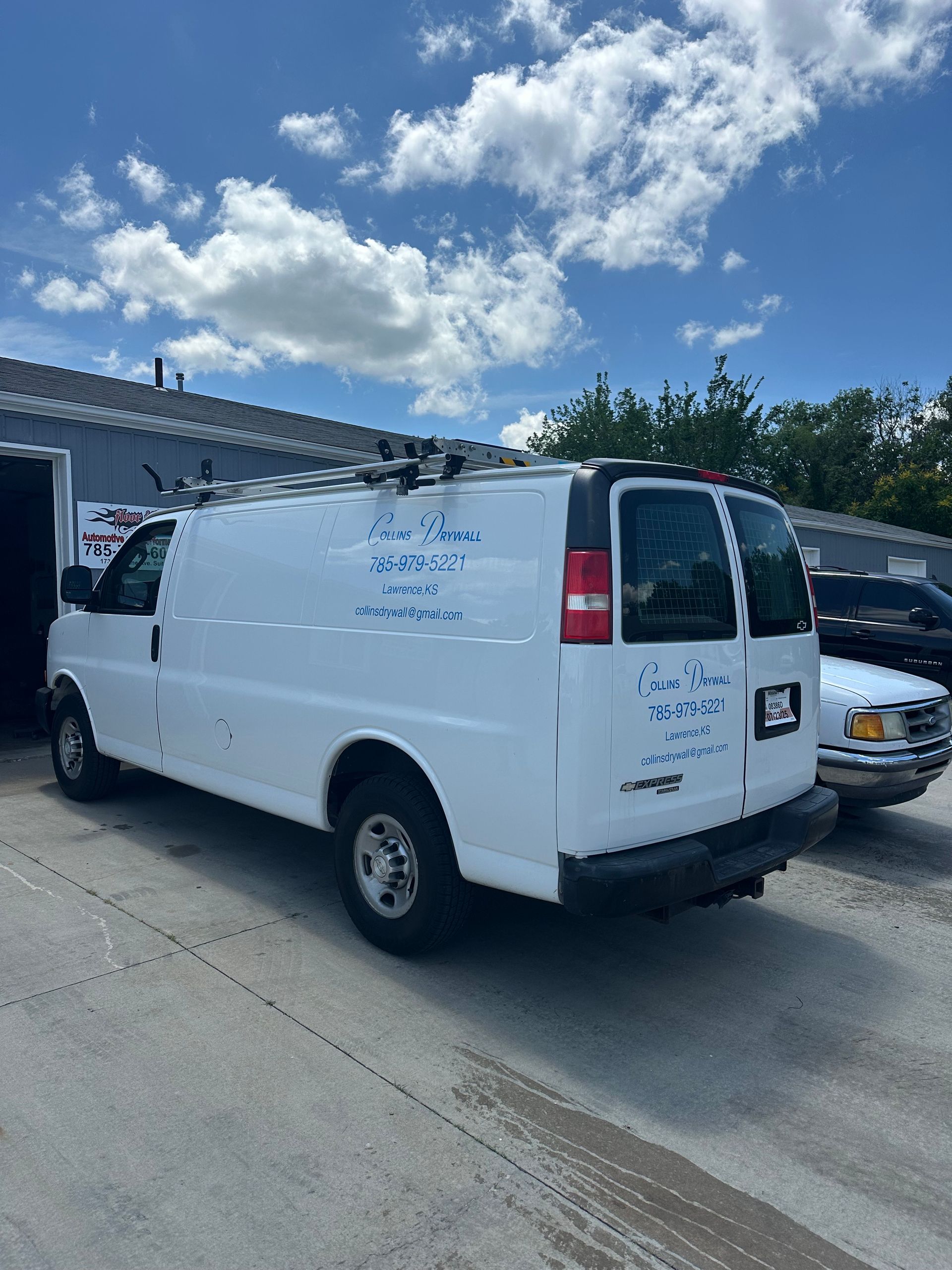 A white van is parked in front of a building.