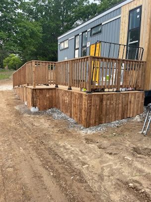 A wooden deck is being built in front of a mobile home.