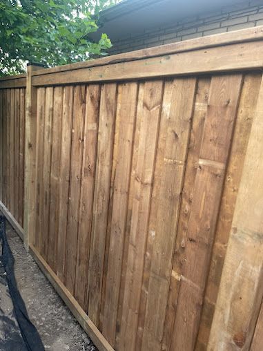A wooden fence is sitting in front of a house.