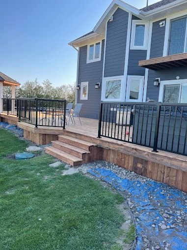 A large house with a large deck and stairs in front of it.