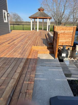 A wooden deck with a gazebo in the background.