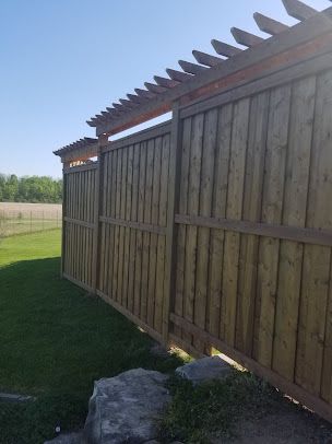 A wooden fence with a pergola attached to it.