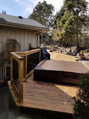 There is a hot tub on the deck of a house.