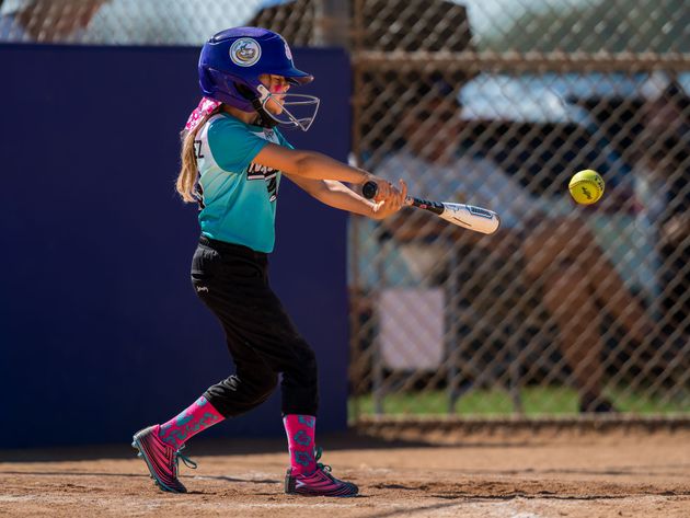 Baseball player sliding into home plate, catcher in front. Blue and gold uniforms, action shot.