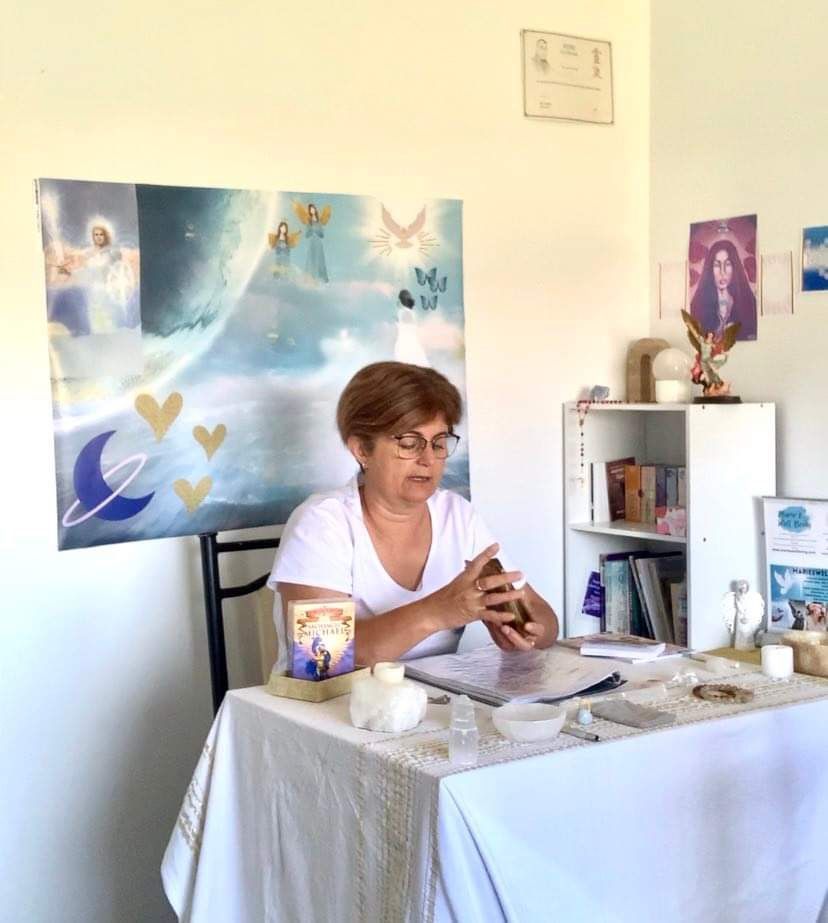 A woman is sitting at a table looking at her phone.