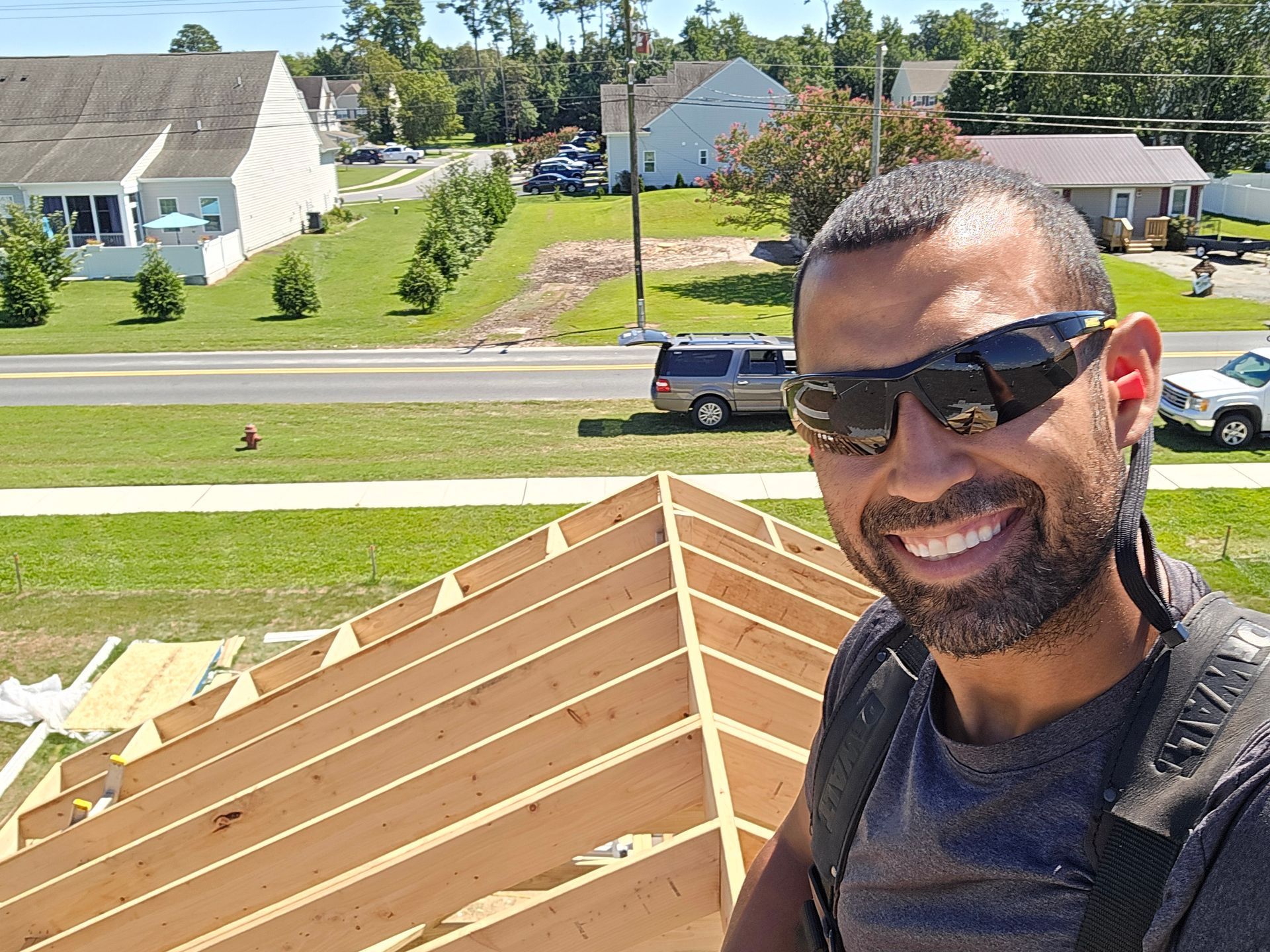 A man is taking a selfie in front of a house under construction.